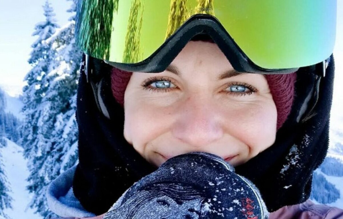 Mujer con gafas de esquí y pasamontañas sonríe frente a un paisaje nevado de alta montaña en Austria, durante una jornada invernal con temperaturas extremas