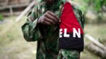 Integrante del ELN con uniforme camuflado muestra un brazalete con las siglas ELN, en el contexto del debate por el Acuerdo Nacional propuesto por la organización armada en Colombia